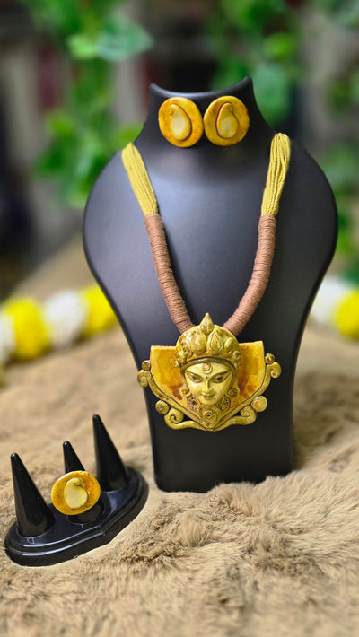 Maa Durga headboard with gold accents on a black stand against a blurred background